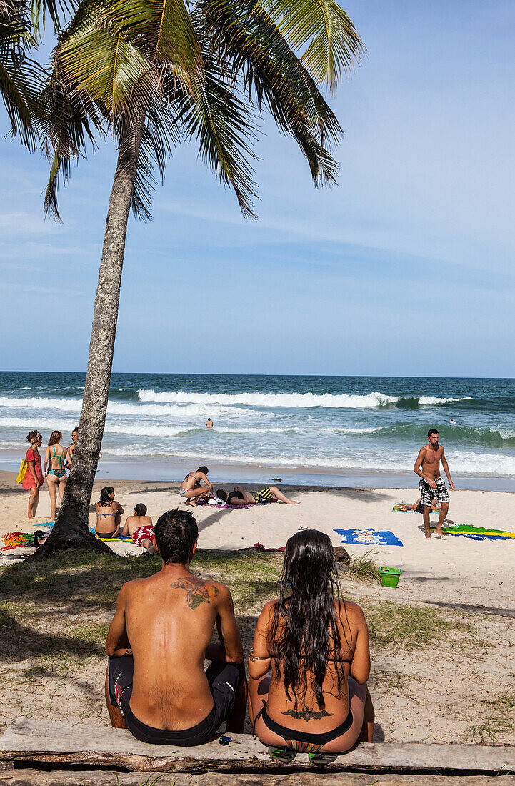 Brazil, Bahia state, Itacaré, couple sitting on the beach