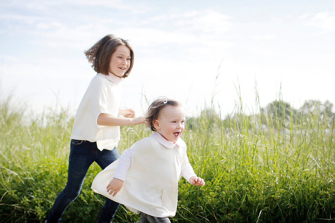 2 young girls running in the country in spring