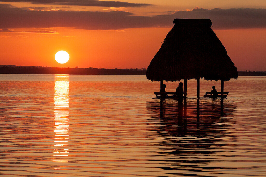 People relaxing at sunset, Lago Peten Itza, El Remate, Guatemala, Central America