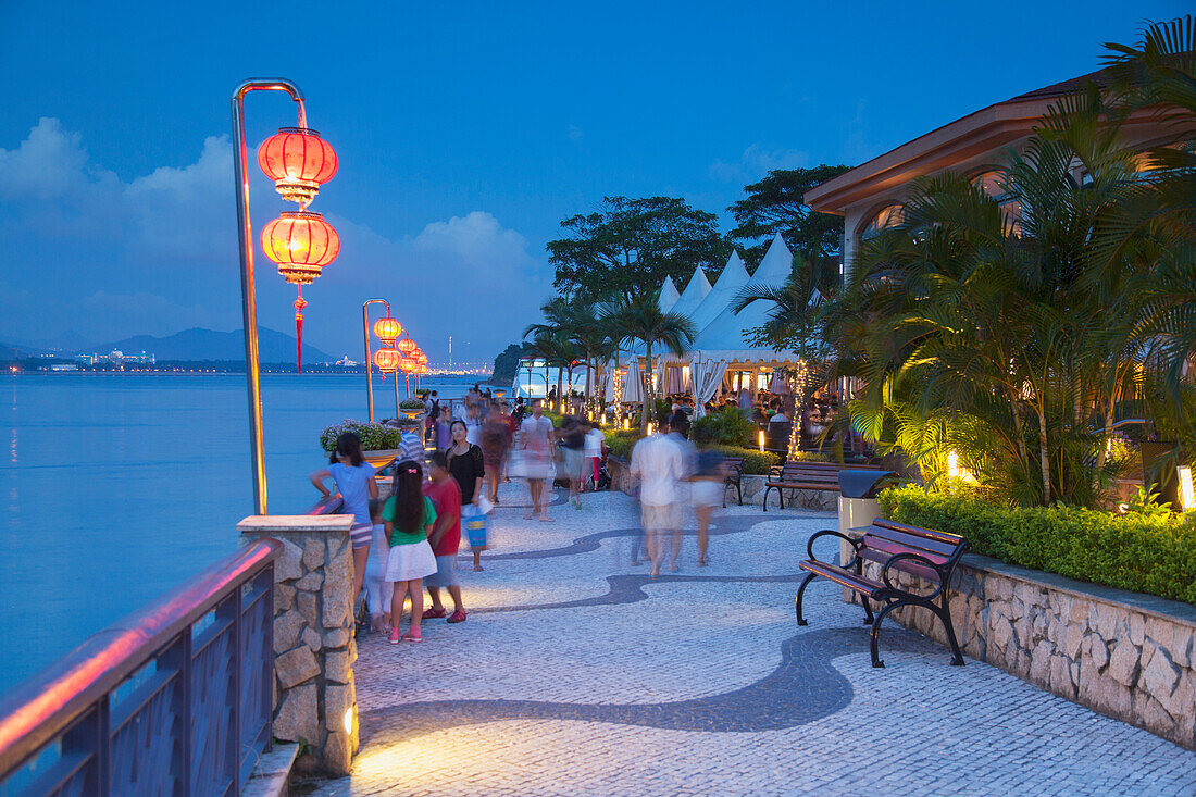 People walking along promenade at dusk, Discovery Bay, Lantau, Hong Kong, China, Asia