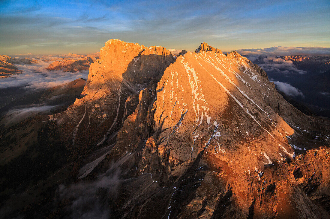 The unmistakable profiles of Sassopiatto (Plattkofel) and Sassolungo (Langkofel) lit by the warm light of the sunset, South Tyrol, Dolomites, Italy, Europe