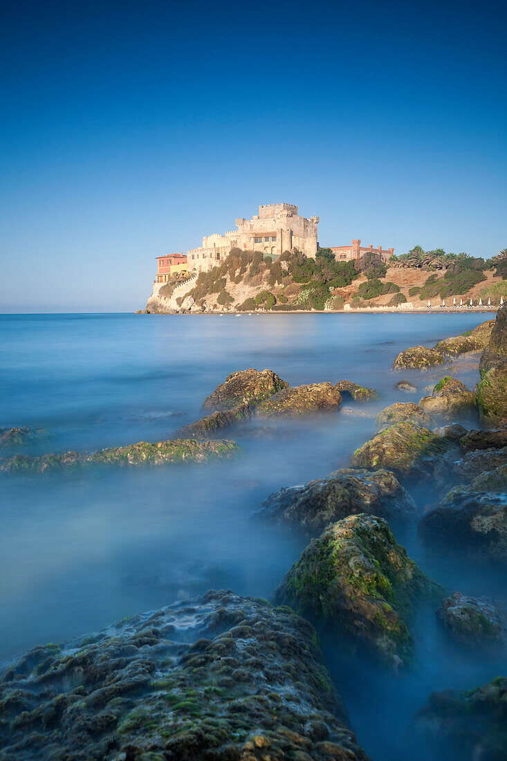 Alongside a picturesque millstone, atop a rocky promontory dominating the sea, rises the Castello di Falconara, Sicily, Italy, Mediterranean, Europe