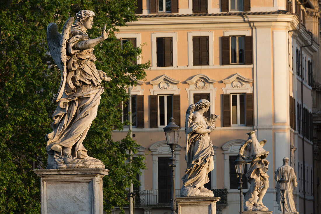 Angel statues on Ponte Sant' Angelo with grand house behind, Rome, Lazio, Italy, Europe