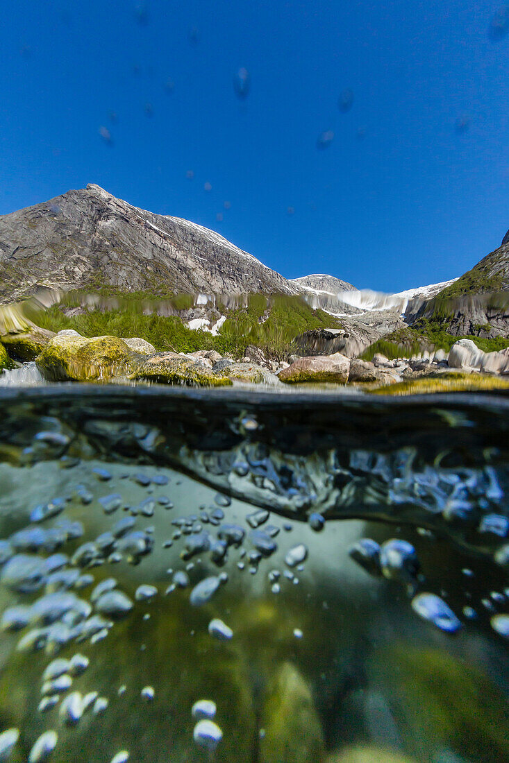 Above and below view of ice melt waterfall cascading down in Svartisen National Park, Melfjord, Nordfjord, Norway, Scandinavia, Europe