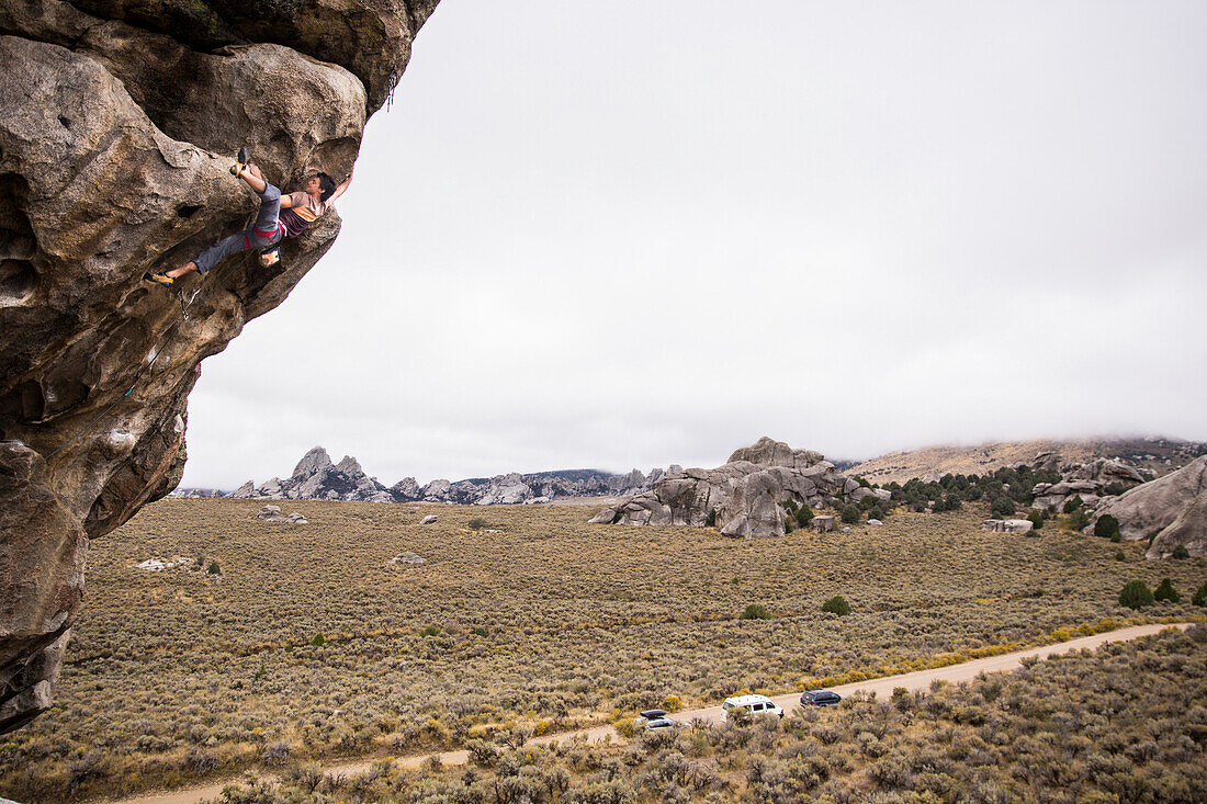 Athletic male rope climbing on a cliff in City of Rocks Idaho