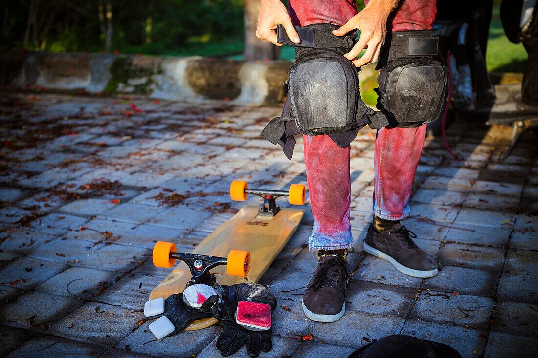 Man preparing for riding on a longboard skate.