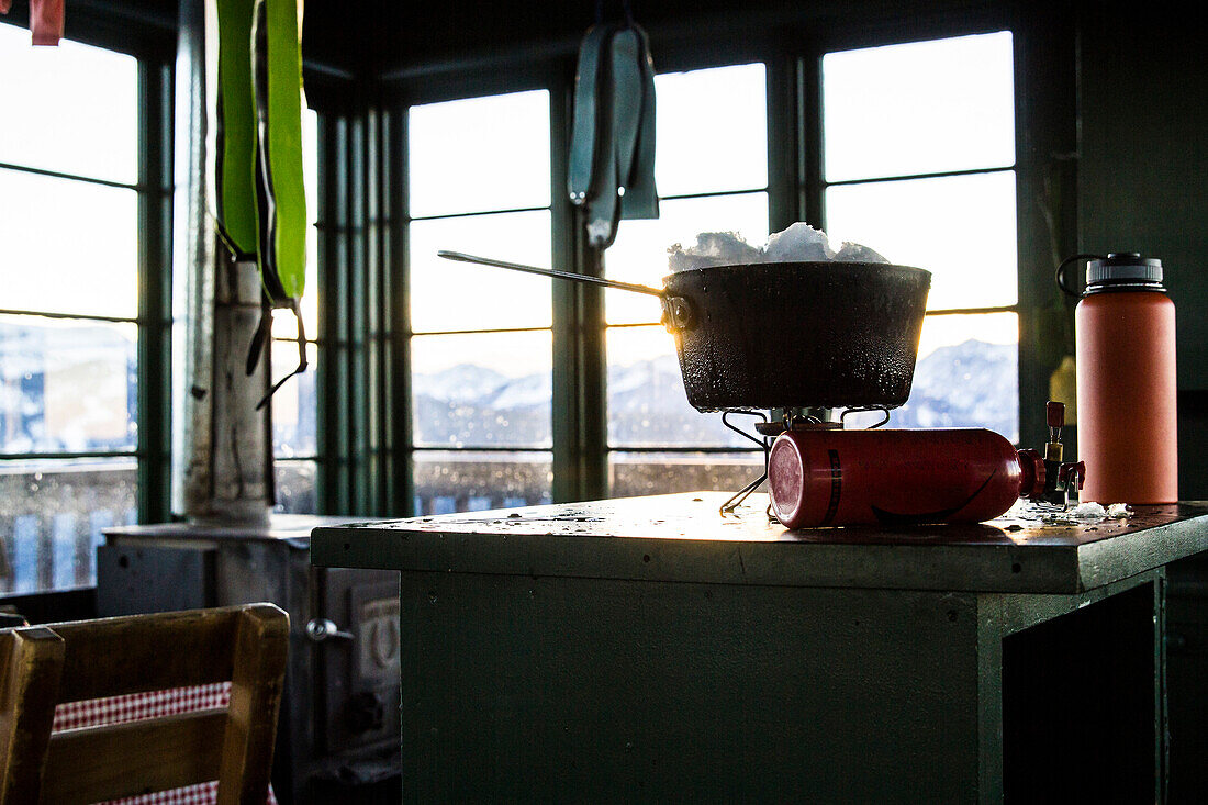 Melting snow on a camp stove in an old fire lookout in Montana.