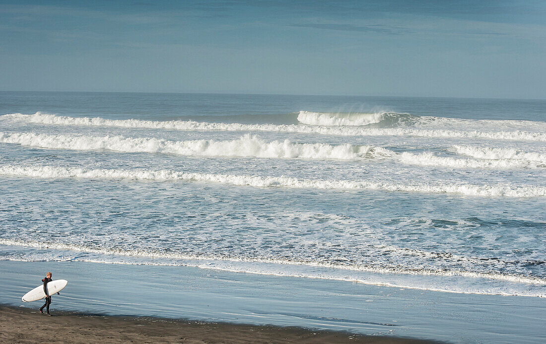 surfer walking ocean beach