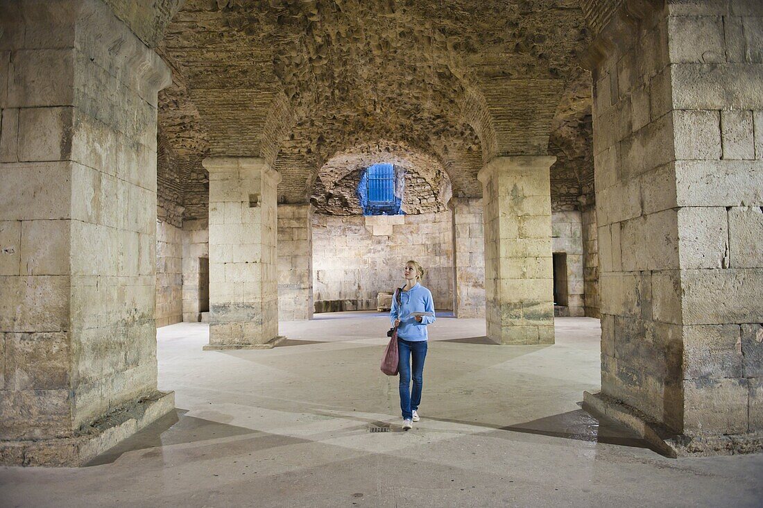 Tourist exploring the underground halls at Diocletian's Palace, UNESCO World Heritage Site, Split, Dalmatian Coast, Croatia, Europe