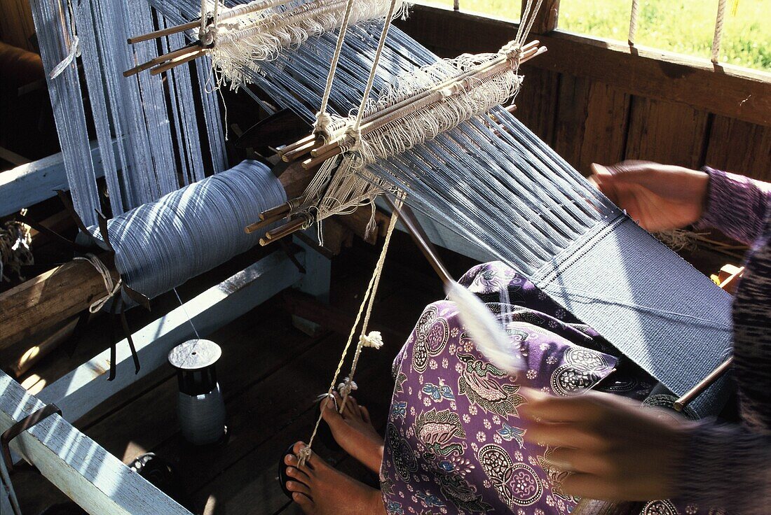 Weaving cotton fabrics on a traditional multiple-harness frame loom, Inle Lake, Shan State, Myanmar (Burma), Asia