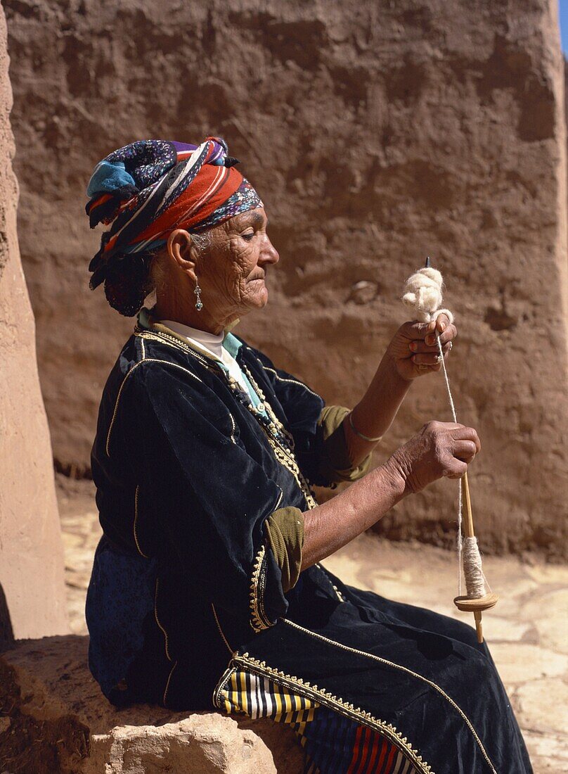 Old woman in traditional dress, demonstrates spinning wool by distaff, near Ouarzazate, Morocco, North Africa, Africa