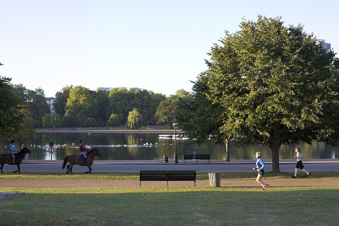 Horse riders and joggers, Serpentine pond, Hyde Park, London, England, United Kingdom, Europe
