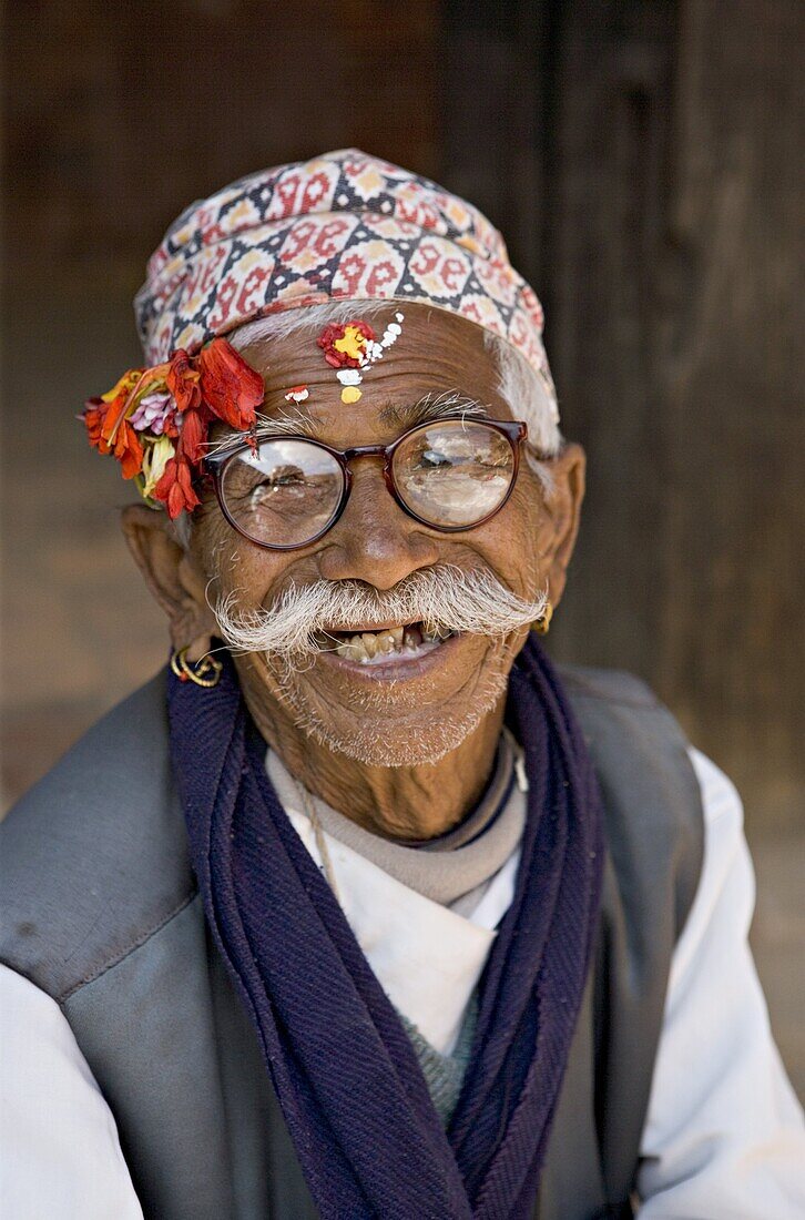 Old Nepali man wearing topi hat in Mul Cowk courtyard, posing for tourists, Durbar Square, Patan, Kathmandu Valley, Nepal, Asia