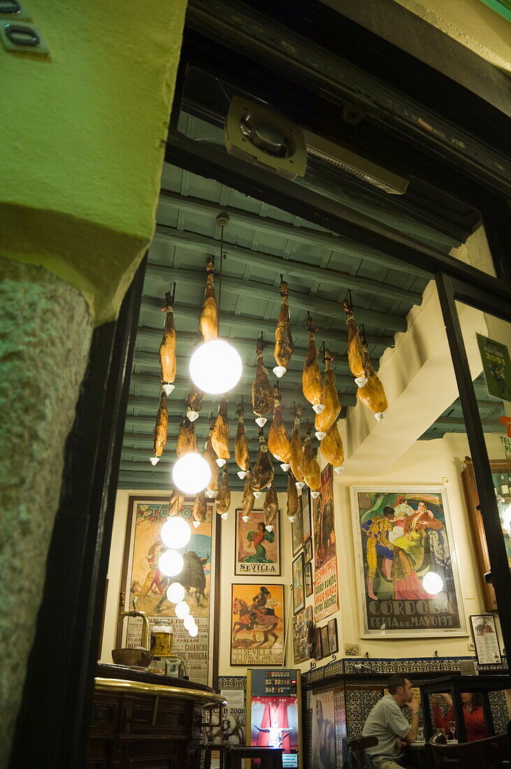 Tapas bar and restaurant with hams hanging from the ceiling, Santa Cruz district, Seville, Andalusia, Spain, Europe