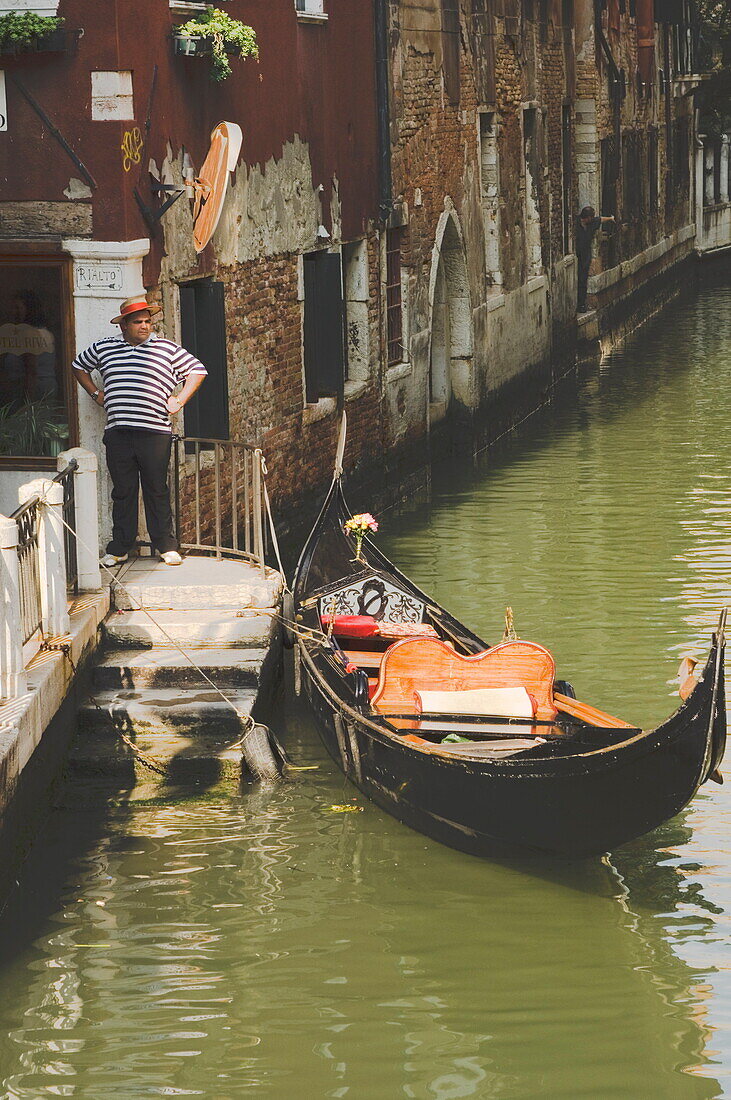 Gondolier and gondola for hire on canal, Venice, Veneto, Italy, Europe
