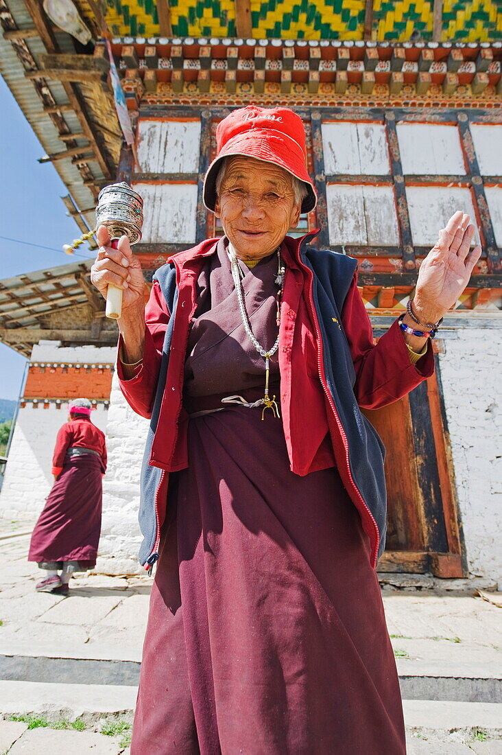 Woman spinning a prayer wheel, Jampay Lhakhang, built in 659 by Tibetan King Songtsen Gampo, Jakar, Bumthang, Chokor Valley, Bhutan, Asia