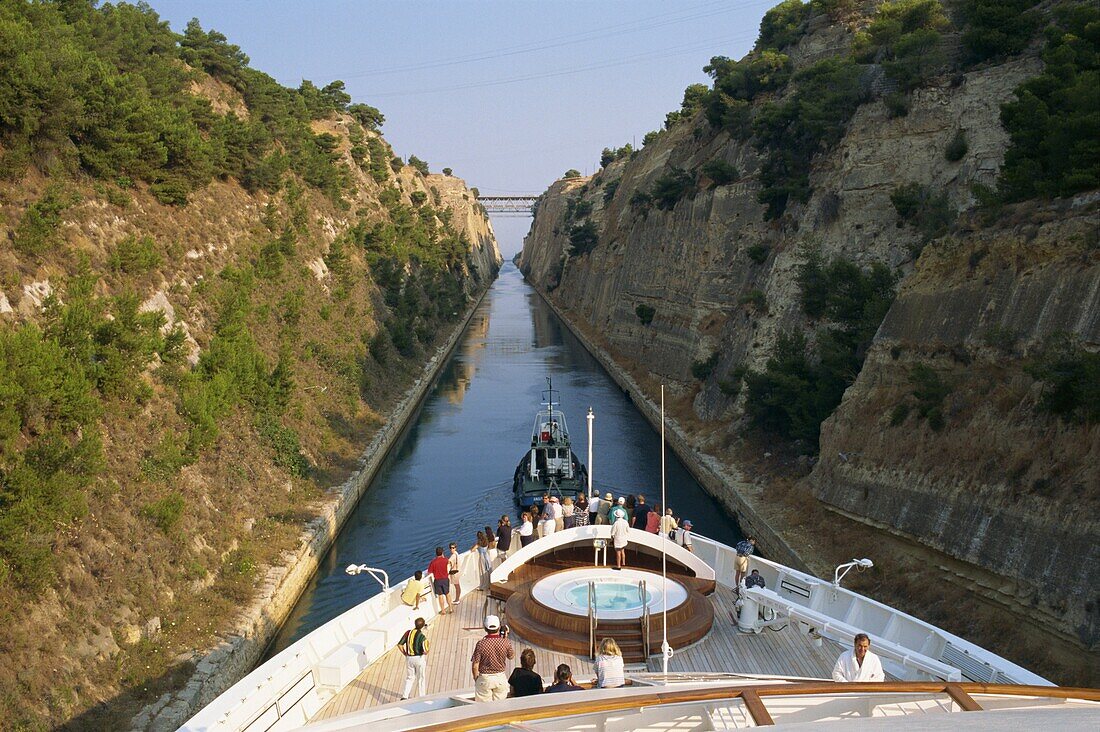 Tourists on the bow of a ship being pulled by tug through the Corinth Canal, Greece, Europe