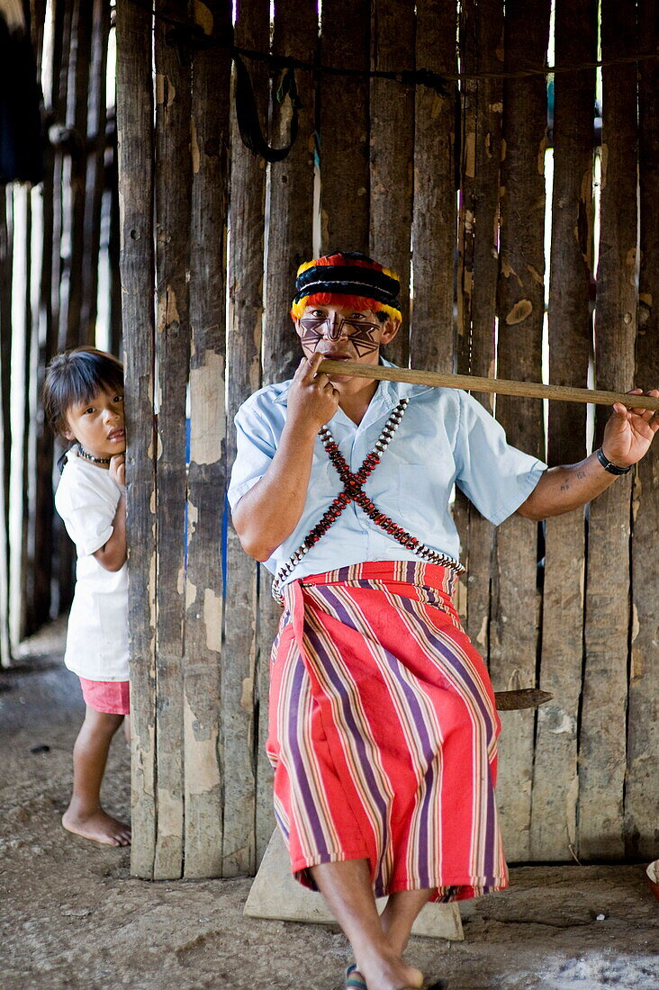 An Achuar man plays an Achuar flute, Amazon, Ecuador, South America