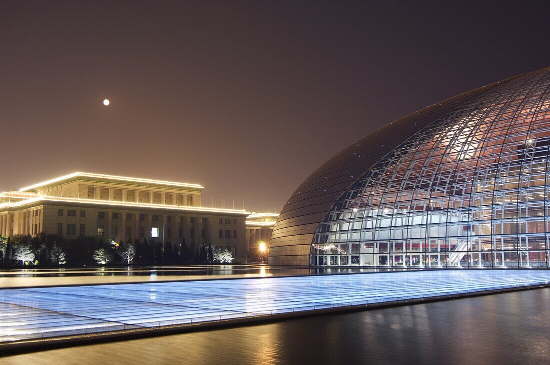 Full moon above Soviet style Great Hall of the People contrasts with The National Theatre Opera House, also known as The Egg designed by French architect Paul Andreu and made with glass and titanium opened 2007, Beijing, China, Asia