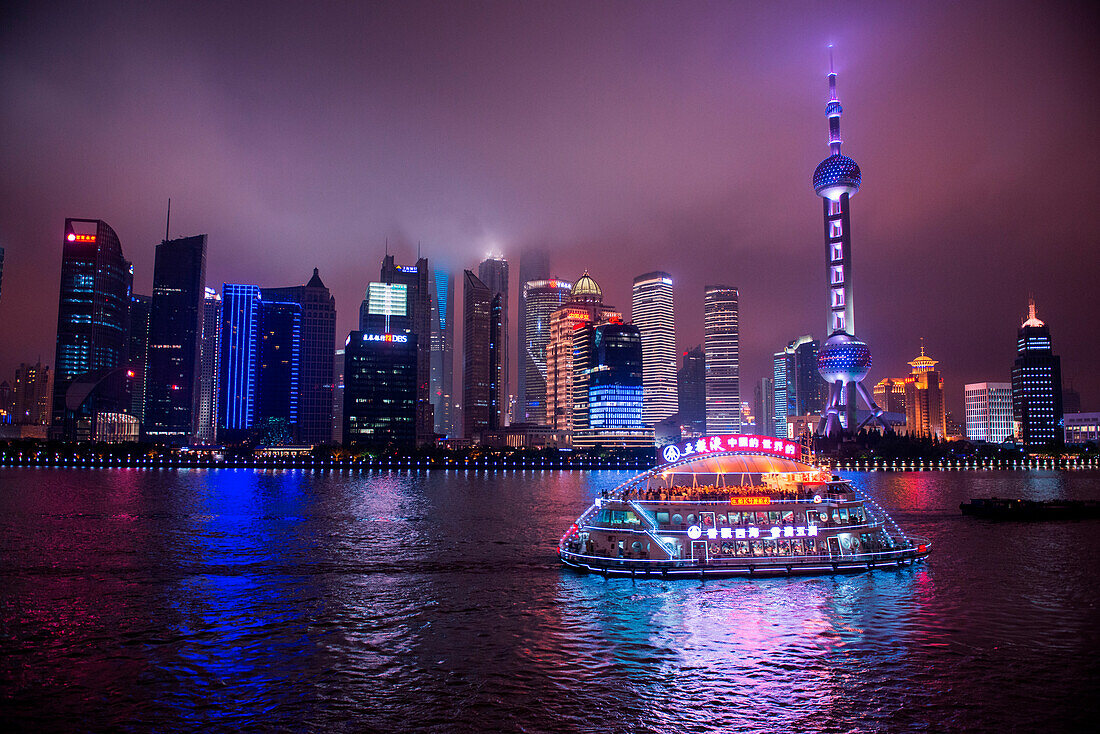 Sightseeing boat on Huangpu River with Oriental Pearl Tower and Pudong skyline at night, Shanghai, Shanghai, Asia