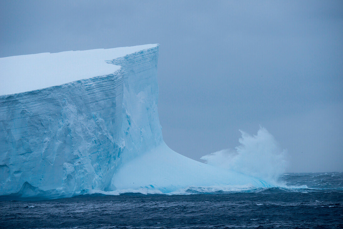 Waves crash against the ca. 30 meter tall face of a 36 kilometer long iceberg (tracking number B17A), near South Georgia Island, Antarctica