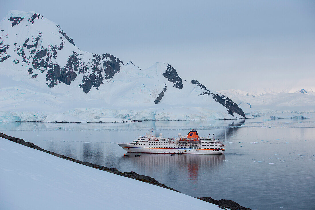 Overhead of expedition cruise ship MS Hanseatic (Hapag-Lloyd Cruises) with majestic mountain backdrop, Paradise Bay (Paradise Harbor), Danco Coast, Graham Land, Antarctica