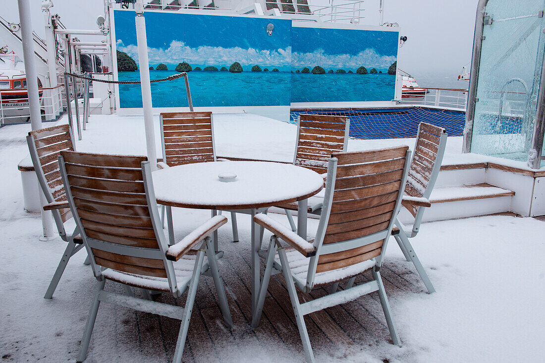 Schnee- und Eisbedeckte Stühle und Tisch an Deck von Expeditions-Kreuzfahrtschiff MS Hanseatic (Hapag-Lloyd Kreuzfahrten), nahe Südshetland-Inseln, Antarktis