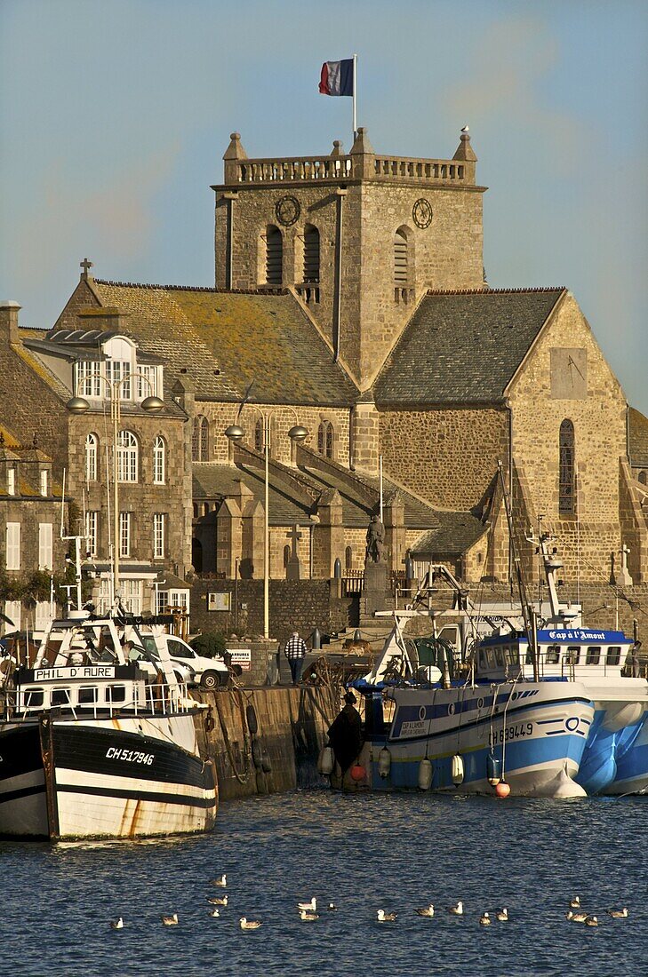 Harbour and fishing boats with houses and church in the background, Barfleur, Manche, Normandy, France, Europe