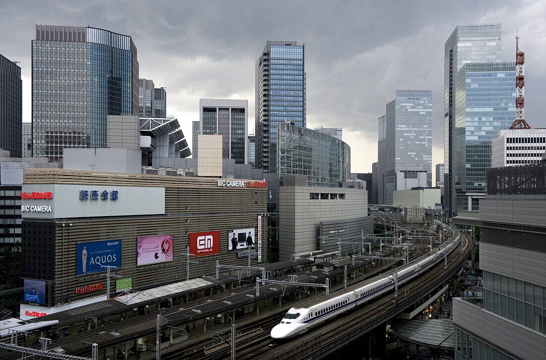 Shinkansen bullet train weaving through maze of buildings in the Yurakucho district of downtown Tokyo, Japan, Asia