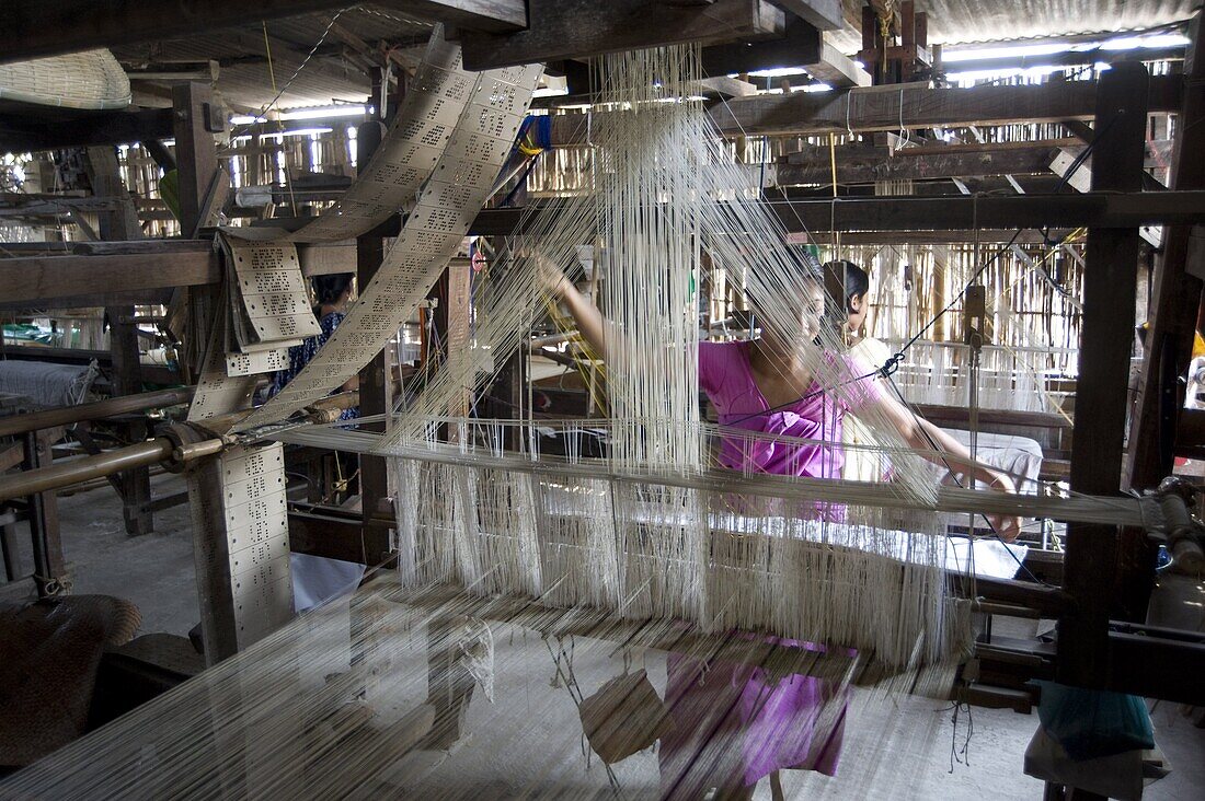 Woman at village silk loom weaving Assam Muga natural undyed silk in Sualkuchi, Assam, India, Asia