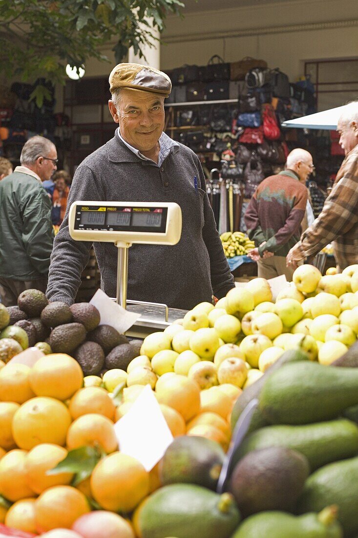 A fruit stall holder works at the Mercado des Lavradores in central Funchal, Madeira, Portugal, Europe