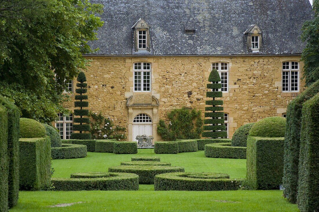 The manor house surrounded by topiary in Les Jardin du Manoir D'Eyrignqac in Salignac, Dordogne, France, Europe