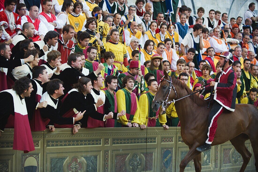 Rider and supporters at El Palio horse race festival, Piazza del Campo, Siena, Tuscany, Italy, Europe