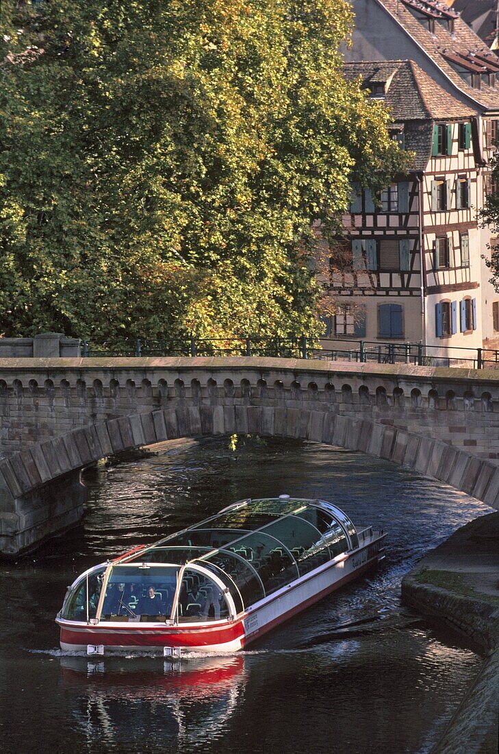 Tourist boat under arch of Ponts-couverts (Covered-bridges) dating from the 14th century, over river Ill, with the Petite France quarter behind, Grande Ile, UNESCO World Heritage Site, Strasbourg, Alsace, France, Europe