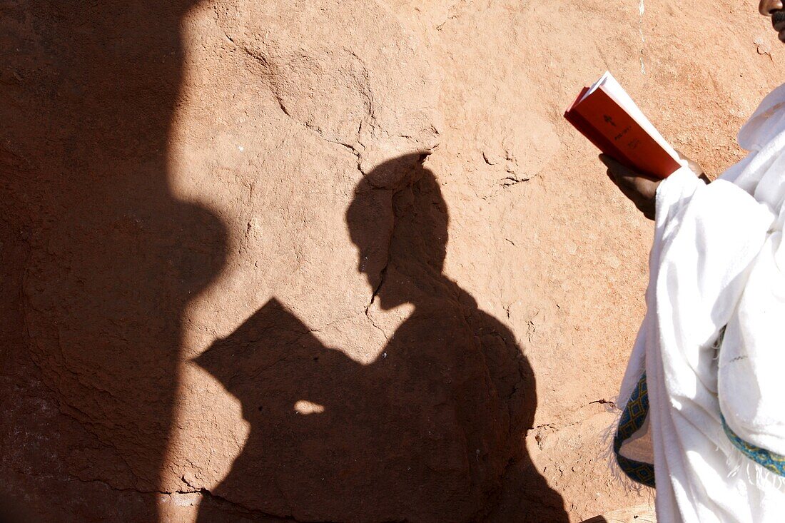 Pilgrim reading outside a Lalibela church, Lalibela, Wollo, Ethiopia, Africa