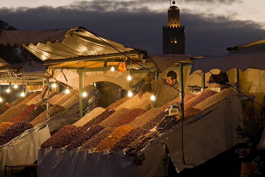 Fruit seller with the Koutoubia minaret behind, Place Jemaa el Fna (Djemaa el Fna), Marrakech (Marrakesh), Morocco, North Africa, Africa