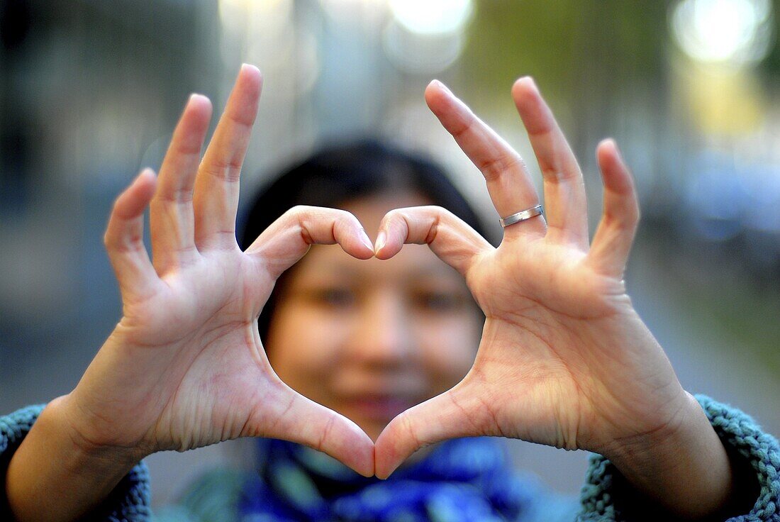 Woman making a heart with her fingers, Paris, France, Europe