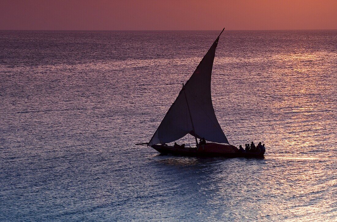 A dhow sailing at sunset near Stone Town, Zanzibar, Tanzania, East Africa, Africa