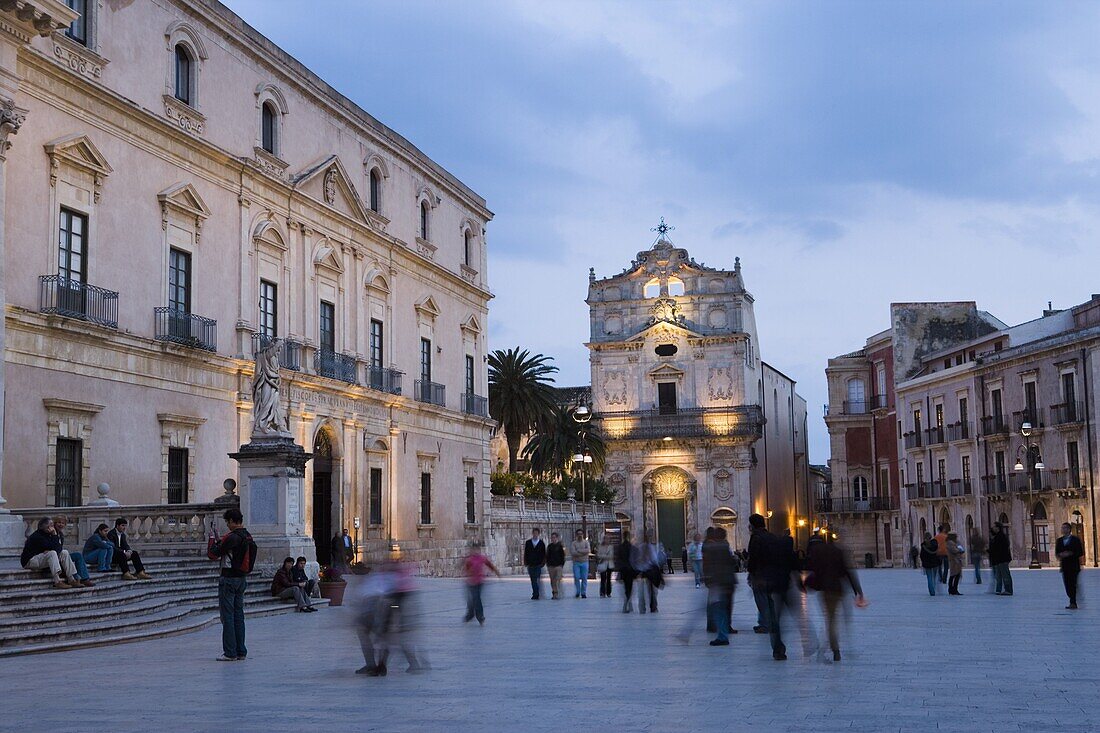 People strolling in the evening, Santa Lucia alla Badia beyond, Piazza Duomo, Ortygia, Syracuse, Sicily, Italy, Europe