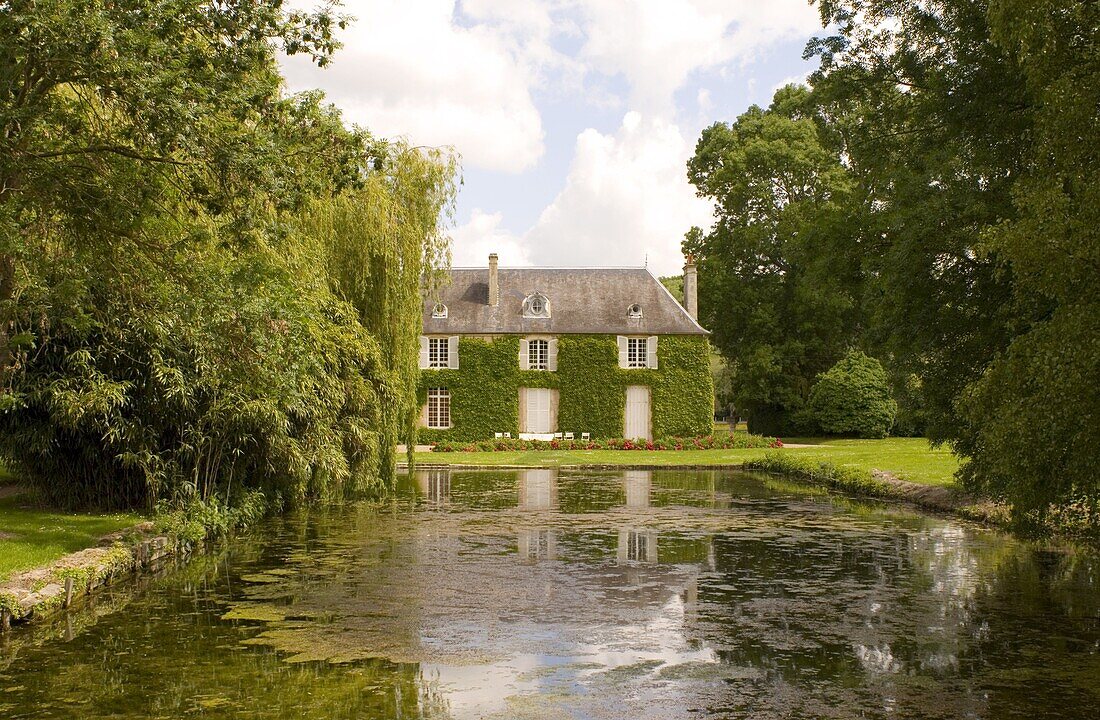 A private ivy covered house with a pond and peonies in front, Normandy, France, Europe