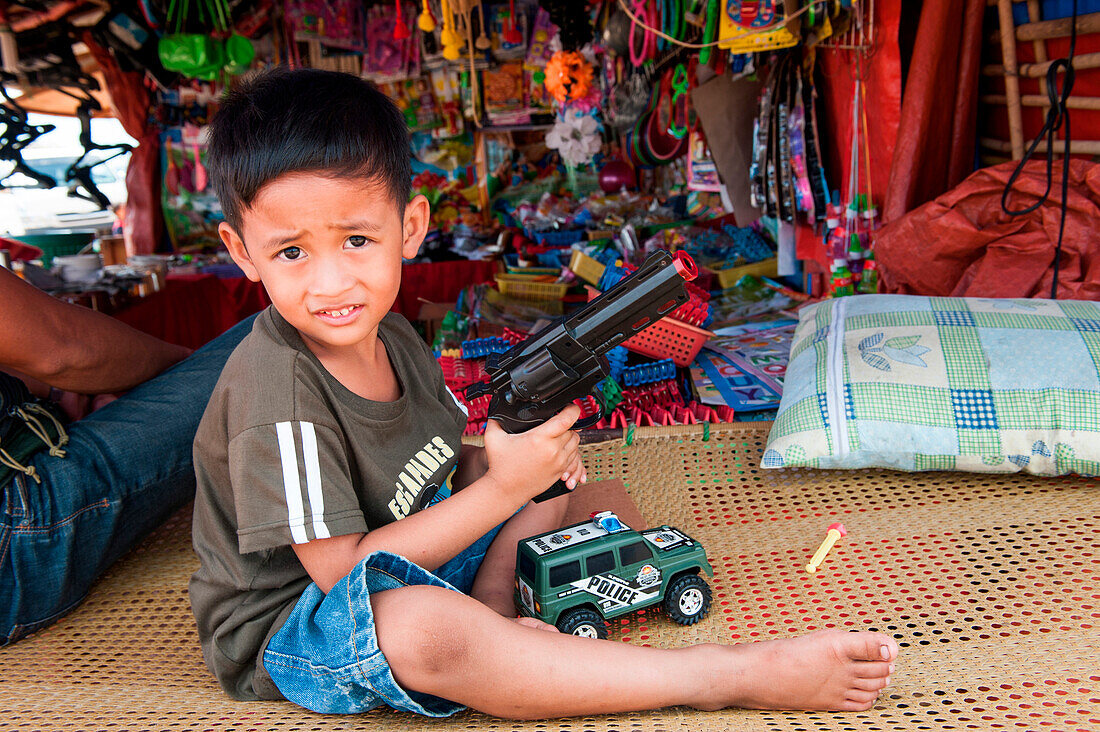 Young boy with toy pistol, Coron, Busuanga, Palawan, Philippines, Asia