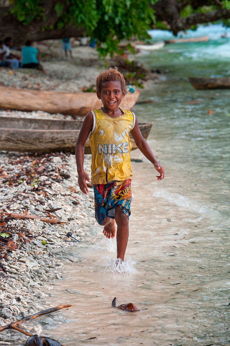 Kleiner Junge im Nike T-Shirt rennt entland Strand, Insel Nendo, East New Britain Provinz, Papua-Neuguinea, Südpazifik
