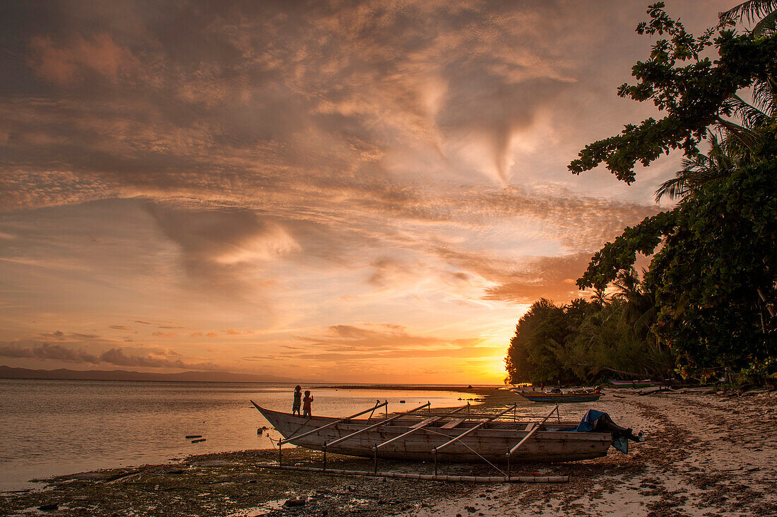 Outrigger canoe on beach at sunset, Biak, Papua, Indonesia, Asia
