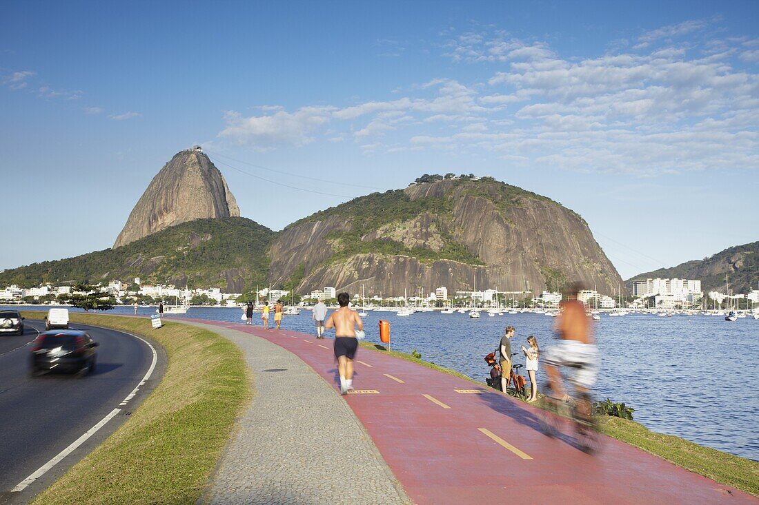 People exercising on pathway around Botafogo Bay with Sugar Loaf Mountain (Pao de Acucar) in the background, Rio de Janeiro, Brazil, South America