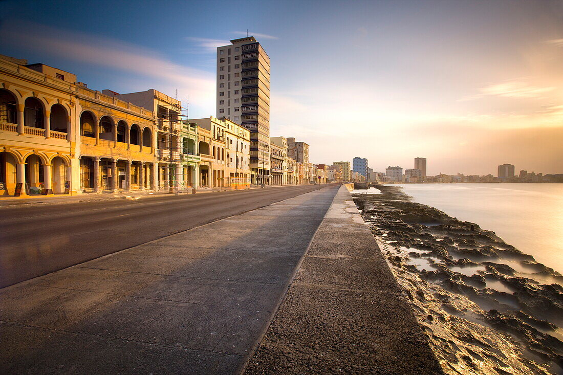 View along The Malecon at dusk showing mix of old and new buildings, Havana, Cuba, West Indies, Central America