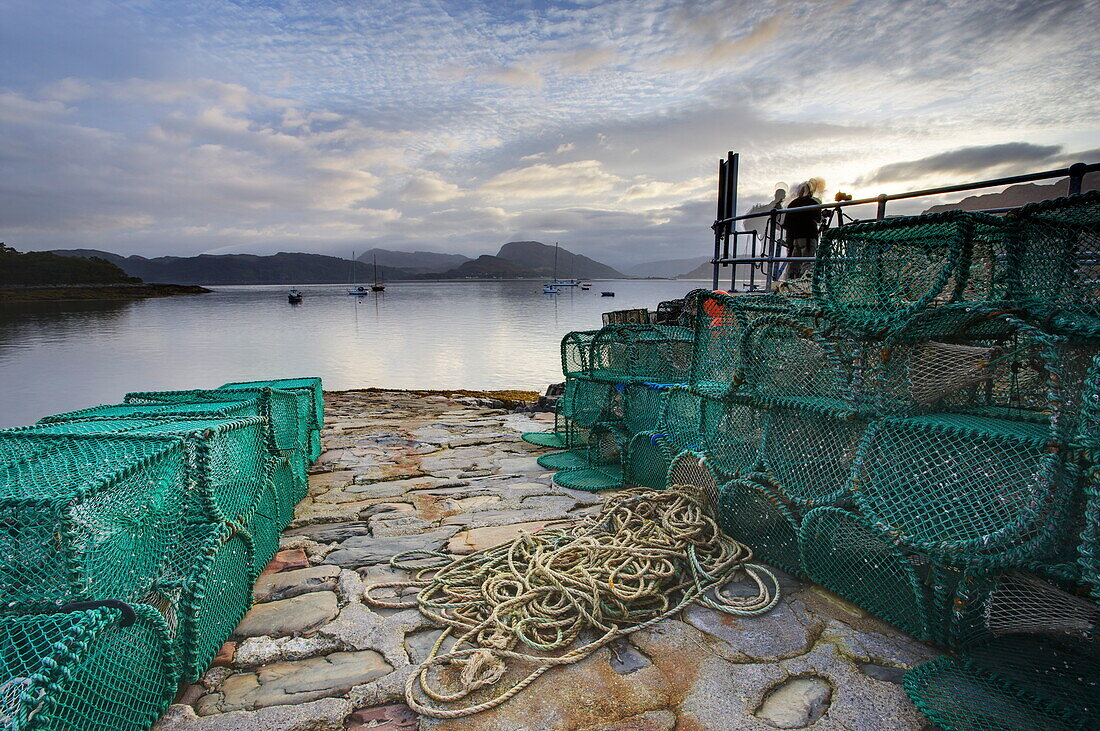 View out to sea from stone slipway at dawn, with lobster pots and ropes in foreground, Plokton, near Kyle of Lochalsh, Highland, Scotland, United Kingdom, Europe