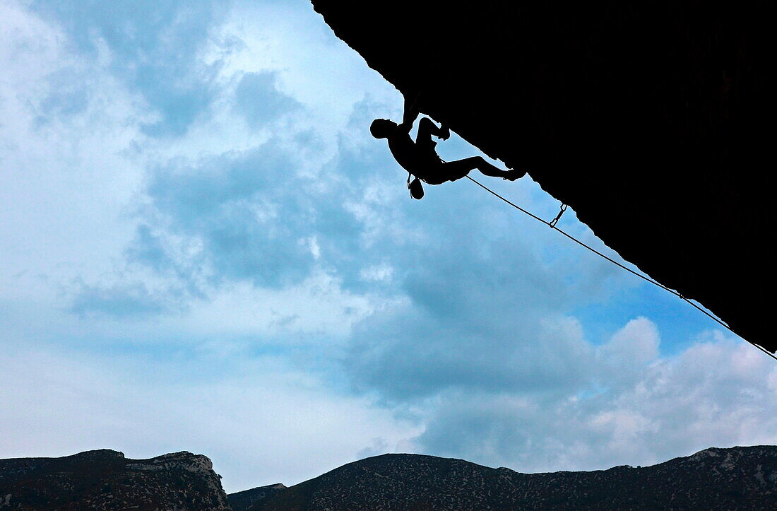 A climber tackles a severely overhanging route in the caves of the Mascun Gorge, Sierra de Guara mountains, Aragon, Spain