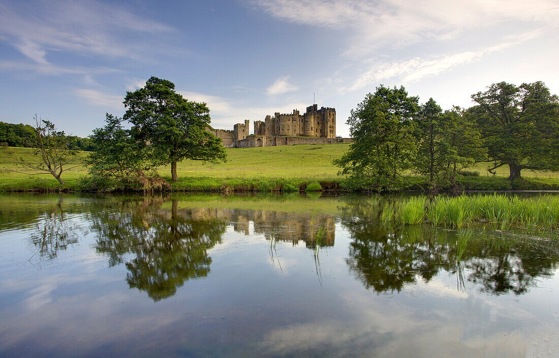 Alnwick Castle reflecting in River Aln, Alnwick, Northumberland, England, United Kingdom, Europe