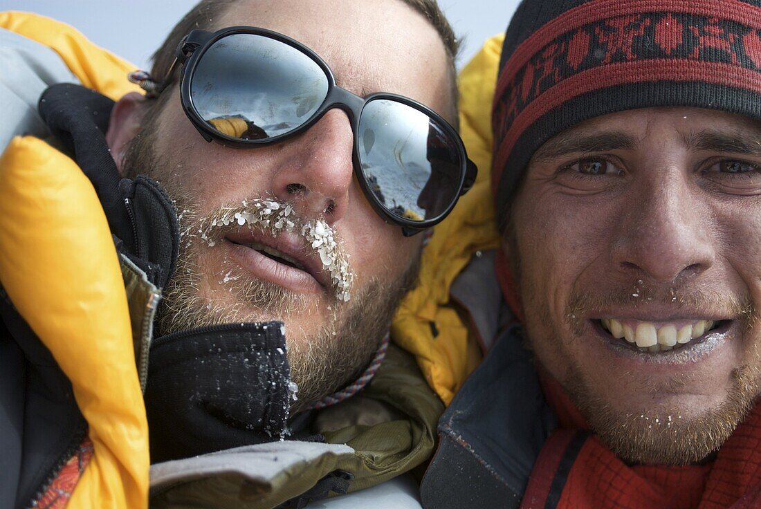 Two 30 year old men embrace on the summit of Mount Denali, Alaska, United States of America, North America