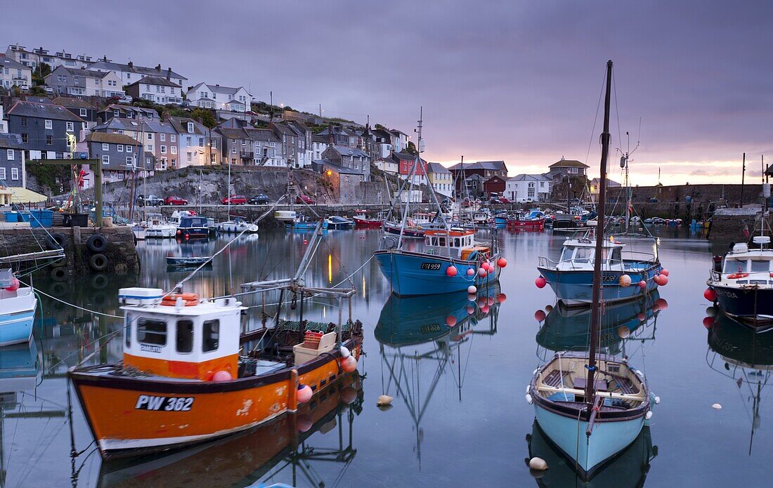 Fishing boats crowd a placid Mevagissey Harbour at dawn, Mevagissey, South Cornwall, England, United Kingdom, Europe